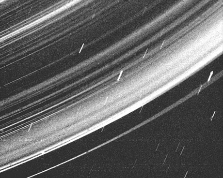 　「Voyager 2号」によるこのドラマチックな写真は、天王星のリング全体で小さな粒子が連続的に分布している様子を示している。Voyager 2号はこの画像を、天王星から23万6000kmの距離で、天王星の影の中から撮影した。解像度は約33kmである。

　この独特の形状はVoyagerが最大の位相角でリングを撮影したもので、ほかの角度からは見えない微細なちり粒子の線を見ることができる。以前から知られているリングはすべて写っているが、この画像で最も明るく写っている部分のいくつかは、以前は観測されていなかった明るいちりの線である。

　この独特の形状と、96秒という長い露出時間を組み合わせ、Voyagerの広角カメラのクリアフィルタを通して撮影することで、この目を見張るような観測が可能になった。この長時間露出によって、目に見える不均一なしみと、星が動いた跡の線ができている。

　Voyager計画は、NASAのためにジェット推進研究所（JPL）によって管理された。