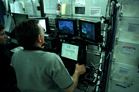 　ISS内から、外部のCanadarm2ロボットアームを操作して、ISSに横付けしたスペースシャトルEndeavourのロボットアームに機材を移そうとしているVoss氏。NASAではこの操作をこの種のものとしては初めての「宇宙での握手」と呼んでいる。Canadarm2ロボットアームは、この写真が撮影された日のわずか6日前、2001年4月22日に取り付けられたばかりだった。