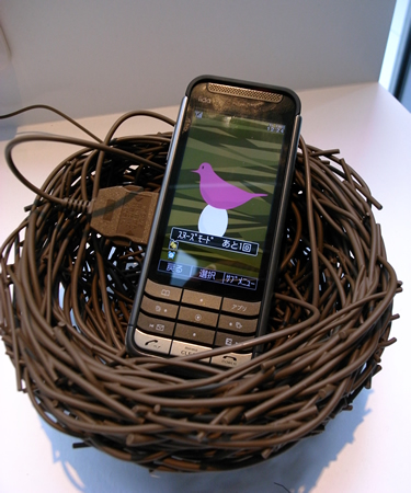 　鳥の巣の形をした携帯電話ホルダー「toris」。充電ケーブルと同じ素材で作られているという。鳥のデザインのダウンロードコンテンツがセットになっており、タイマーをセットすると鳥の鳴き声で知らせてくれる。デザイナーは関祐介氏。