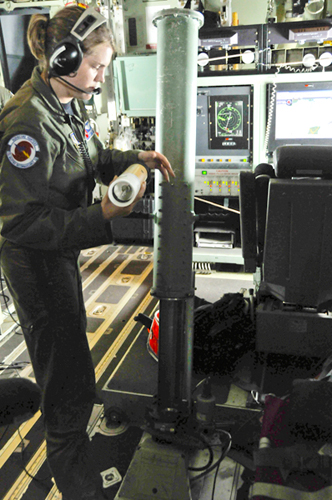 　乗組員のShannon Smith三等軍曹が、アイク観測の飛行中にドロップゾンデ投下の準備をしている。