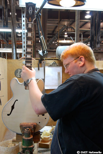　Gibsonの従業員がネックを本体に取り付けながらギターを点検しているところ。この作業は、7日間の工程の他のすべての作業と同様、神経を使う。ネックが正しい位置に取り付けられていなければ、弦の角度がおかしくなり、音が外れてしまう。