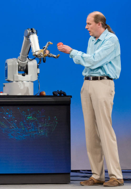 　Intel Research SeattleのプリンシパルエンジニアJoshua Smith氏は、このロボットが持つ、「（リンゴに）触れる前に」リンゴの位置を察知し、掴める能力を披露した。ロボットは、Smith氏の腕も掴んだ。
