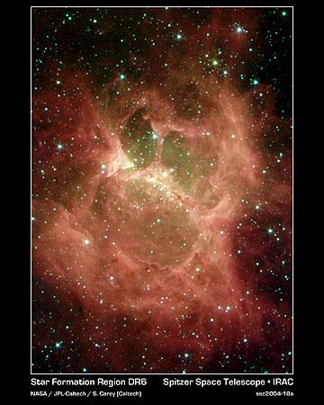 　くぼんだ両目の鬼が叫んでいるようなこの生まれたばかりの星の雲は、Spitzerの赤外線カメラによって発見された。この化け物のような雲は、私たちの銀河系の平面にある「DR 6」という名前の星雲で、太陽の10倍から20倍の質量を持つ、約10個の巨大な生まれたばかりの星の群れが存在する。星雲の「目」と「口」は、中央の縦線、すなわち「鼻」の位置にある星から放出されたすさまじい高温と風によるものだ。目、口の中にある緑色の物質はガスで構成されており、赤色の領域と巻き毛は、若い星に命を与えたちりの雲を構成している。

　DR 6は3900光年離れており、はくちょう座の中にある。中央の縦線の端から端までの距離は約3.5光年で、私たちの太陽から、最も近い星であるケンタウルス座アルファ星までの距離とほぼ同じだ。