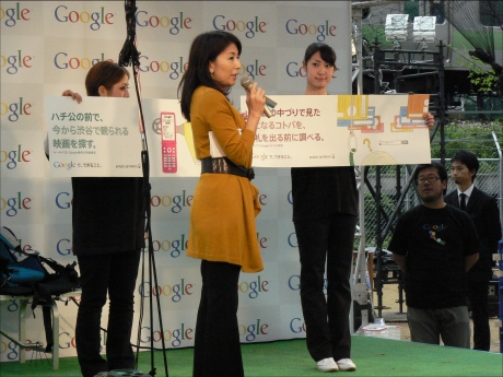 準備が整い、Googleのマーケティングマネージャー 平山景子氏から、「Googleで、できること。」のプレゼンテーションが始まった。このキャンペーンでは、Googleが自社サービスをユーザーの日常シーンに当てはめて、ビデオなどで紹介する。さらに、今回開催された「渋谷で空を飛ぶ。」にあわせて、山手線の車両内に全面広告を掲示している。山手線の原宿〜渋谷間ではイベント会場を車窓から見ることもできる。

スタッフが掲げているのは山手線内に掲示される広告のイメージ。「中吊りで見た気になるコトバを、改札を出る前に調べる」という利用シーンとともにあるキーワードが書かれている。平山氏はそのキーワードについて、「女性なので恥ずかしい」と読み上げてくれなかった。いったい何と書いてあったのだろうか。