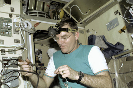 　ISSに滞在する乗組員は、さまざまな道具を使いこなせなければならない。2001年3月に撮影されたこの写真で、フライトエンジニアのJames Voss氏はZvezdaサービスモジュールの中ではんだ付け作業を行っている。

　ISSのクルーは全員が長いキャリアを積んだ宇宙飛行士というわけではない。最近、ISSでは何人かの「宇宙旅行者」を迎えており、その中にはソフトウェア業界の重鎮Charles Simonyi氏（2009年春、再びISSを訪れる予定）やコンピュータゲームの開発者Richard Garriott氏などが含まれている。そのほか、Googleの共同創設者Sergey Brin氏や投資家であり評論家でもあるEsther Dyson氏など、テクノロジ業界の著名人がISSへの宇宙旅行を希望している。