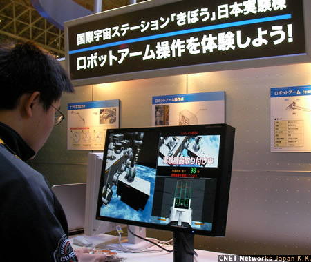 　NECブースでは、ロボットアームを操作して、国際宇宙ステーション「きぼう」に装置をドッキングさせるというゲームを展示していた。NECの宇宙への取り組みをアピールするのが狙いだ。