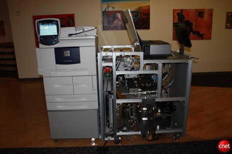 　「Espresso Book Machine（EBM）」のメーカーであるOn Demand Booksは米国時間9月17日、パブリックドメインのデジタル書籍を集めたGoogleのライブラリにアクセスし、EBMで利用するための許可を得たことを発表した。これに先立ち同メーカーは16日、カリフォルニア州マウンテンビューにあるGoogle本社に実際にマシンを持ってきて、書籍が印刷、製本される様子を披露した。このマシンの価格は構成によって7万5000ドル〜9万7000ドル。図書館や本屋などの設置を意図して販売されており、300ページの書籍を4分間で印刷し、カバーを付けて製本することができるという。
