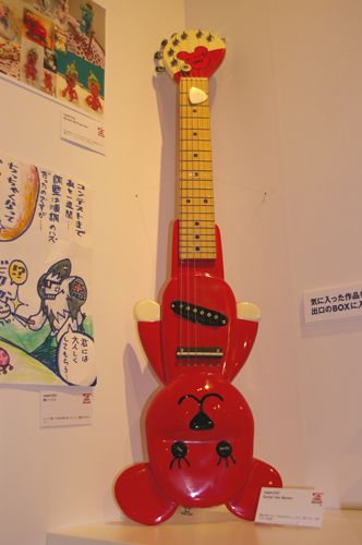 ユーザー作品展示から。「これも手作り？」とびっくりするほど精巧なつくりの「Guitar The Momo」。モモちゃんカラーのぴかぴかピンクボディが会場内でも目を引く。