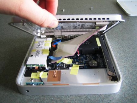 　4本のケース用ネジを外したら、そっとベースプレートを持ち上げる。ハードディスクは、まだベースプレートに付いたままだ。これをプレートから完全に取り外してしまう前に、ハードディスクにつながっているATAケーブルを外さなければならない。