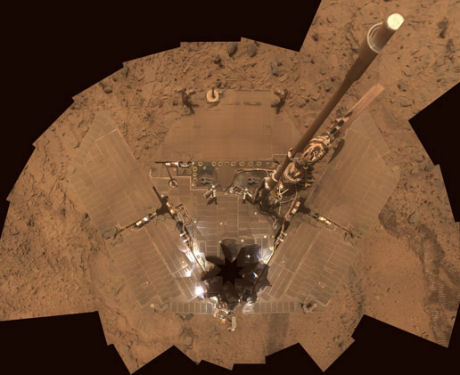 　火星探査車Spiritが自分を撮影した画像。砂ぼこりにまみれ、非常に長い火星の冬をしのぐ場所を探しているところだ。あとで出てくるが、Spiritがこれまでに集めた画像から、大昔に温泉または噴出口があったことを示す証拠が見つかっている。地球の6月ごろに、火星では凄まじい砂嵐が2台の火星探査車を襲った。搭載機器やソーラーパネルが大量の砂ぼこりをかぶったことで、Spiritは深刻なパワー不足に悩まされている。火星の赤道付近に展開しているもう1台の探査車Opportunityは、砂ぼこりが突風で吹き払われたため、Spiritよりはずっとよい状態にある。火星探査車Spiritが砂まみれになっているこの画像は、火星滞在1355ソル目から1358ソル目（ソルは火星の1日で24時間40分に相当）にかけて、Spiritが搭載しているパノラマカメラで撮影した複数の写真から作成されたもの。垂直方向の画像で、地面とアンテナがゆがんでいる。撮影したカメラの支柱は、8つの突起からなる星形の部分の下にある。