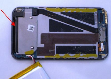 　バッテリは、液晶ディスプレイの背面のプレートに接着剤で固定されている。われわれのiPod touchには、はがさなければいけない接着剤がたっぷりあった。端のテープにも注目してほしい（赤の矢印）。