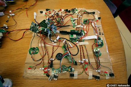 　回路とサーボと配線で覆われているこのボードは実は、Pleoの内臓部。モータ、ボディ、目などは別にある。開発中はこうしたボードを使ってテストを行い、そのたびに1体を作り上げることはしない。