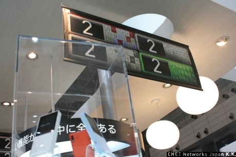 　KDDIはCEATEC JAPAN 2007のブースにおいて、中央に夏モデルを大々的に並べ、端末中心の構成をとっている。ただ、携帯電話以外のもさまざまな最新技術も展示された。先日発表された「INFOBAR 2」展示コーナーの周囲にはいままでのデザイン端末も飾られている。