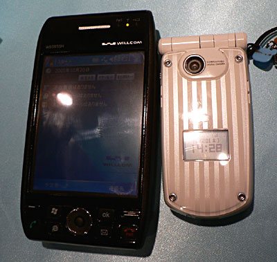 　大きさは幅約70mm×高さ約130mm×厚さ約26mm（キーボード収納時）。NTTドコモの携帯電話「P901i」（右）と比べると、やはりかなり大きい。