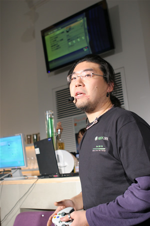 　マイクロソフトXbox事業本部オンラインビジネスグループシニアマーケティングエグゼクティブの鶴淵忠成氏は無線コントローラを使ってXbox 360の新機能を紹介するとともに、実際にゲームをデモンストレーションで披露した。