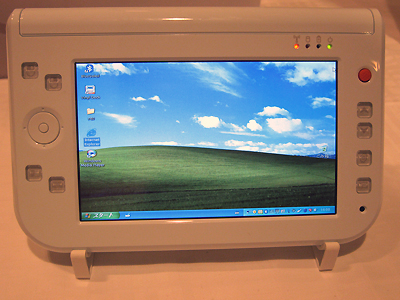 PBJは4月4日、日本におけるUltra Mobile PC（UMPC）の第一弾端末となるPBJの「Smart Caddie」を発表。同日より予約販売を開始した。写真は、起動した画面。Windows XP Tablet PC Edition 2005が搭載されている。カーソル操作は、右上の赤いボタンで行える。左側の□ボタンは、上の段がマウスボタン、中央にエンターキー、下段がランチャーメニューキーと文字入力メニューキーが付いている。大人から子供まで、だれでも使える操作性を追求したという。