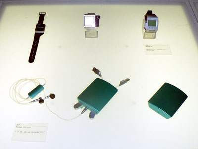 　シチズン時計と共同で開発した時計型PCの「WatchPad」（上）。下は、日本人がポケットに最もよく入れているものの1つが英語学習関連のものであるという調査をもとに開発した英会話学習システム。