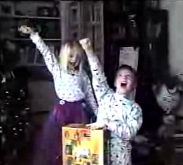 　パジャマ姿の2人の子供がクリスマスの朝に「NINTENDO64」を見つけて大喜びする様子。