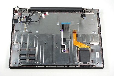　薄い金属のフレームがCr-48の前面（この写真では下の方）の縁に取り付けられている。このフレームはタッチパッドの裏面を覆い、タッチパッドとSSDのケーブルも固定している。フレームは9本のプラスねじでケースに固定されている。