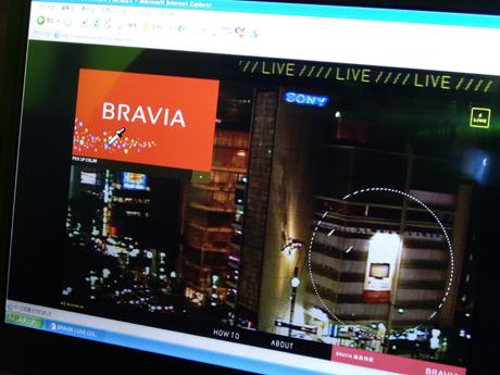 ウェブ上の操作画面。ソニービルのリアルタイム映像画面が流されているウインドウの左上にBRAVIAのCM画面が流される。ユーザーはそのCM画面上から好みの色をチョイスし、ビル上の丸い点線内へドラッグ。