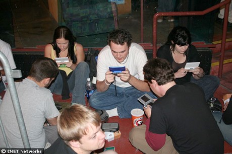 　行列の中には、任天堂の「ニンテンドーDS」のワイヤレス通信を使い「マリオカート DS」で対戦している集団。