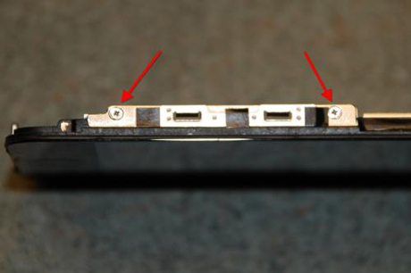 　6つのねじで液晶ディスプレイをフロントカバーに固定している。この写真に写っているのはそのうちの2つのねじで、さらにカバーの反対側に3つ（黒いテープで隠されている）、ディスプレイの裏側に1つある。