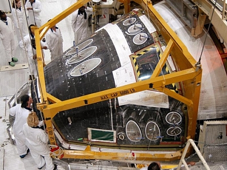 　オービタ整備施設の職員たちが、STS-114ミッションに備えて、DiscoveryのForward Reaction Control Systemが所定の位置まで降ろされるのを見守っている。

　Forward Reaction Control Systemは、ピッチ、ロール、ヨーに推進力を与える。