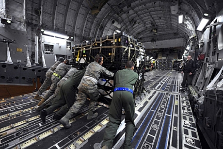 　沖縄の普天間飛行場において航空機「KC-130J Hercules」内で作業する第3海兵遠征旅団の海兵隊員たち。食料、水、医療品を運んでいる。