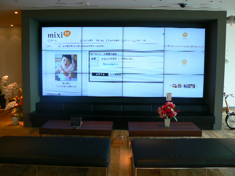 【2011年4月の新オフィスの写真】
受付付近に置かれたモニターではSNS「mixi」を紹介する動画が流れていた。