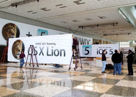 　Lion、iOS 5、iCloud用の横断幕を参加者の登録エリアの天井に吊しているところ。WWDCの参加者は6日の朝からここで列を作ることになる。