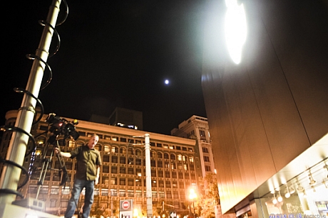 　月とApple Storeのロゴに照らされながら、テレビ局のクルーが店舗前の様子を撮影している。