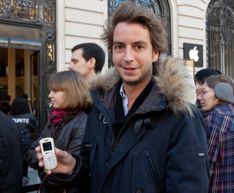 　7台目のiPhoneを買うために列に並んでいたパリ在住の男性。手にしている携帯電話は、iPhone 4を2週間前に紛失して以来使っている端末。