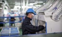 中国の成都にあるAppleのサプライヤーの工場でレーザーエッチングマシンを操作する作業者