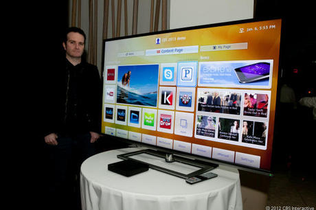 　米CNETのTy Pendlebury記者が、L9300シリーズの65インチの機種と並んで立つ。画面に映るのは東芝の新たなSmart TVのホームページ「Cloud TV」。
