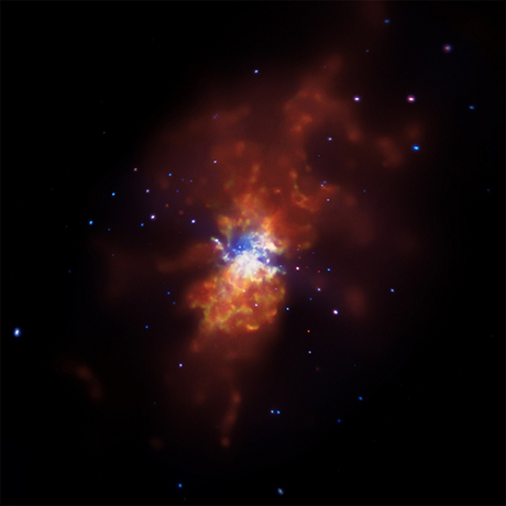 　Chandra X線観測衛星が撮影した「Messier 82（M82）」の画像は、急速な星形成の結果を示している。M82は地球から約1200万光年の距離にあり、宇宙が今よりもずっと若く、多くの星形成が起こっていた時代によく似た環境を持つ場所としては、地球に最も近い。

　M82は、星形成が普通の銀河より数十倍～数百倍速いペースで起こるスターバースト銀河だ。星が誕生するときの爆発は、別の銀河との近接遭遇や衝突によって引き起こされている可能性があり、銀河の至る所に衝撃波を放射する。M82の場合は、数百万年前に近くの銀河「M81」と接触したことで、このような急激な星形成が始まった、と天文学者は考えている。

