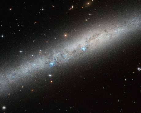 　この画像では、明るい青白い光を発する渦巻銀河「IC 5052」の一部を垣間見ることができる。