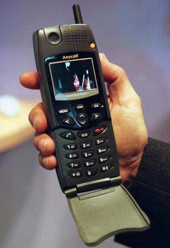 　1999年10月10日にジュネーブで開催されたTelecom 99 + Interactive 99展示会の冒頭で、革命的な「Millennium Multimedia Phone IMT-2000」を披露するサムスン電子。