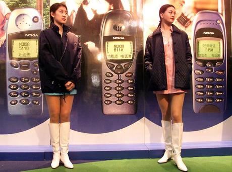 　北京のショッピングモールで、Nokiaの携帯電話を宣伝する同社の2人の女性スタッフ。1999年当時、中国の携帯電話契約者数は2300万人超だった。2012年には、優に10億を超える人々が中国で携帯電話サービスを契約している。