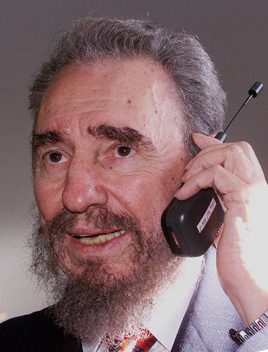 　1998年10月18日、第8回イベロアメリカ首脳会議の2回目のワーキングセッションを前に携帯電話で話す、キューバのFidel Castro議長。ポルト（ポルトガル）のアルファンデガプレスセンターにて。