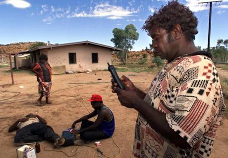 　1999年1月、オーストラリア中央部のアリススプリングスの郊外にある先住民居住区で、パプンヤに住むアボリジニのDenis Minor氏が、タナミ砂漠にいる兄弟に携帯電話を使って電話をかけている。