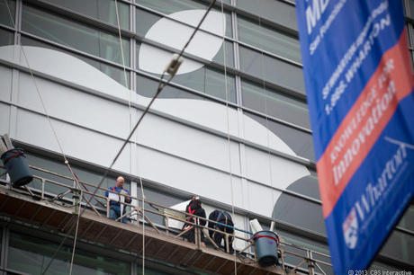 　世界最大と思われるAppleのロゴをモスコーンウェストの外側に貼付ける作業員。6月5日に撮影。
