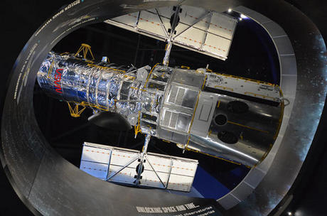 　63フィート（約19.2m）の高さにつるされたハッブル宇宙望遠鏡の実物大模型が、下階にあるスペースシャトルAtlantisの新しい展示場を訪れる見学者を見下ろしている。
