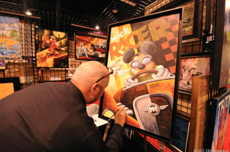 　D23 Expoで自作の絵画「Mick Racer」を手直しするアーティストのMike Kungl氏。