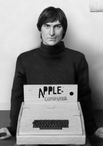 　「Apple I」のミニチュア模型の後ろでポーズを取る80年代初頭版Young Steve Jobsフィギュア。