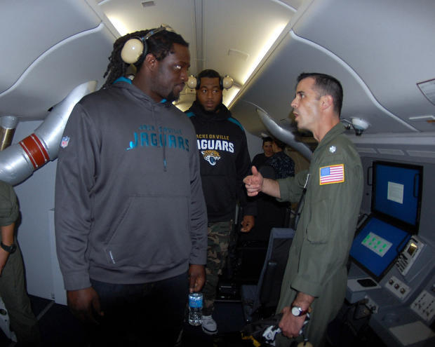 　またJacksonville Jaguarsの登場だ。これは2013年11月に同チームのSen'Derrick Marks選手（左）とWill Rackley選手の2人が、第16哨戒飛行隊の指揮官であるDaniel Papp中佐にPoseidonの機内を案内してもらっているところ。