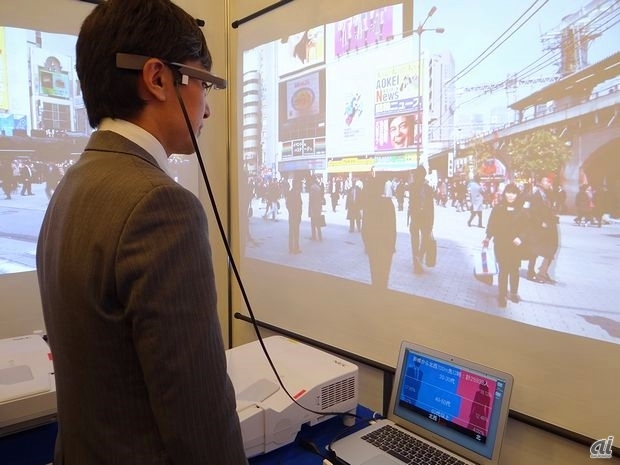 　野村総合研究所（NRI）は、NTTドコモが提供する携帯電話ネットワークを使って作成された人口統計情報「モバイル空間統計」をもとに、Google Glassに自分が向いている方向のエリアの性別、年齢別の人口を時間ごとに表示する「街スカウター」を展示。
