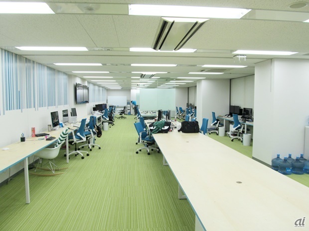 　縦長のオフィスエリアは、部署や業務を超えて社員全員でコミュニケーションがとれる、大きな一つの空間。写真左側の壁には、バーコードをモチーフとしたデザインが施されています。最大席数は67人を想定しているそうです。