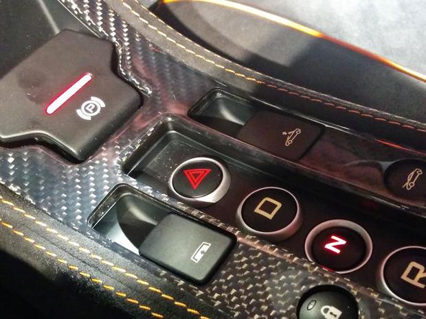 　中央操作パネルのさらに下方には、パーキングブレーキのレバーと、トランスミッションモードを選ぶボタンがある。ドライブ、ニュートラル、リバースはあるが、パーキング専用のボタンはない。