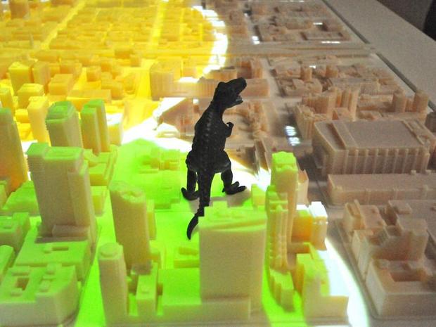 ゴジラと3Dプリントされたサンフランシスコ

　サンフランシスコ発--3Dプリントされた都市のモデルが、将来都市計画に大いに役立つツールになるのではないだろうか？Autodeskや設計会社であるSteelblueの人たちはそう考えている。この2社は、米国時間5月28日に、彼らの言う過去最大のサンフランシスコの3Dプリントモデルを披露した。これは、過去に作られたどんな都市の3Dプリントモデルよりも大きいかもしれないという。これは、不動産開発会社であるTishman Speyerがサンフランシスコのダウンタウンで進めている事業を可視化するためにデザインされ、作られたものだ。このモデルは、同市の115のブロックを1250分の1のスケールで再現している。このモデルの上にジョークで置かれたゴジラのおもちゃが、とても大きく見える。 