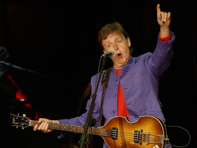 左利き用ベースギターを抱えてステージに立つ元The BeatlesのPaul McCartneyさん